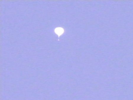 A balloon flying in s blue sky